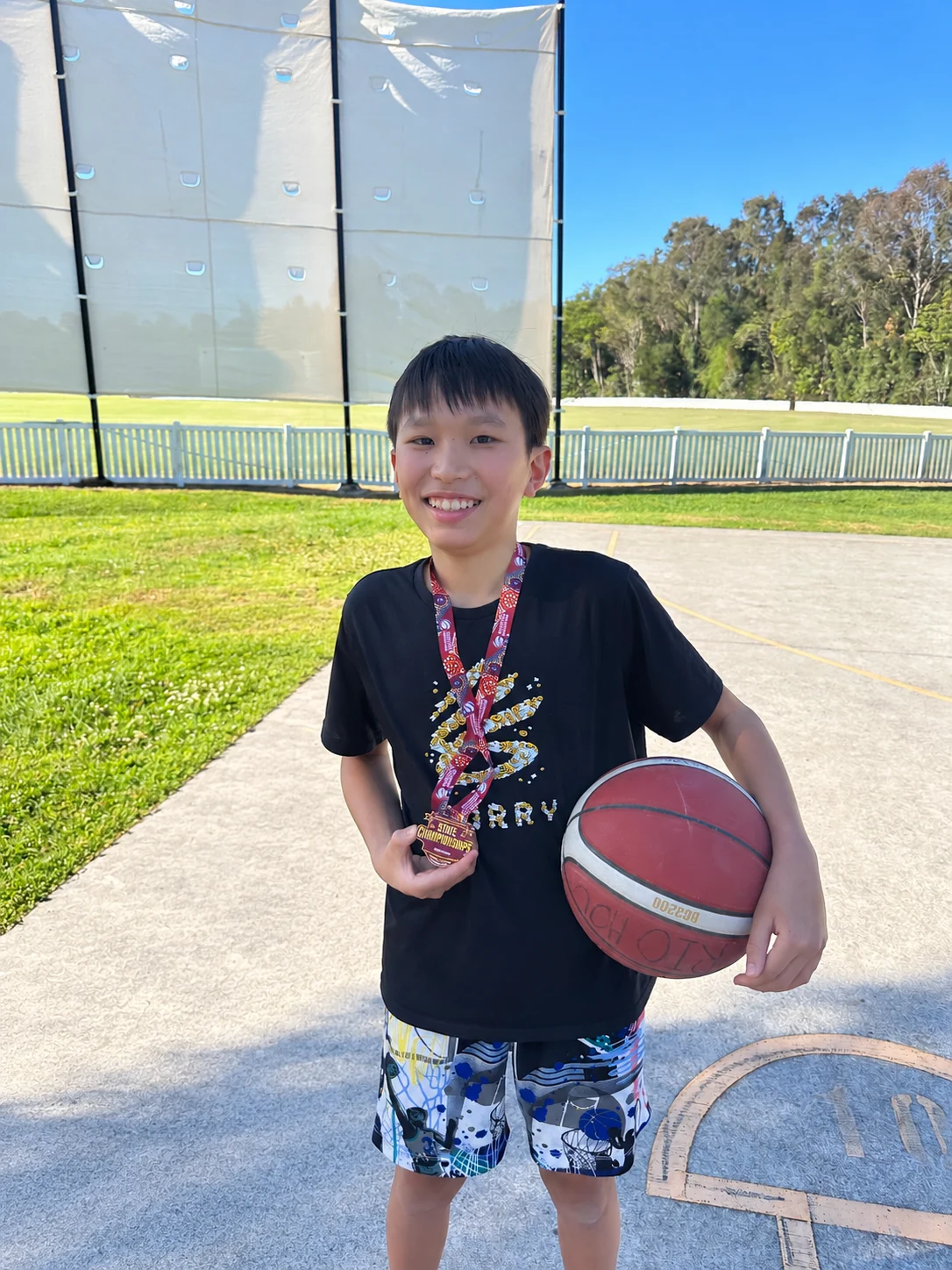 Rio holding his representative basketball championship medal